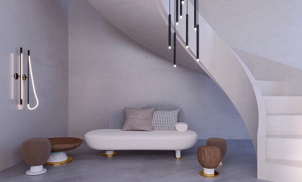 Sculptural sofa on brass and marble feet beneath a curved staircase
